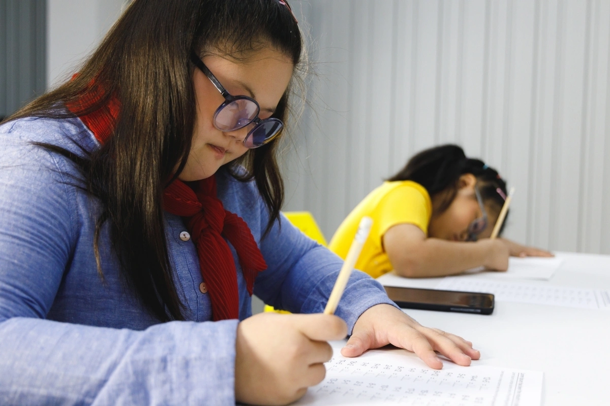 Estudiante interactuando con material didáctico digital adaptado en su escritorio de estudio